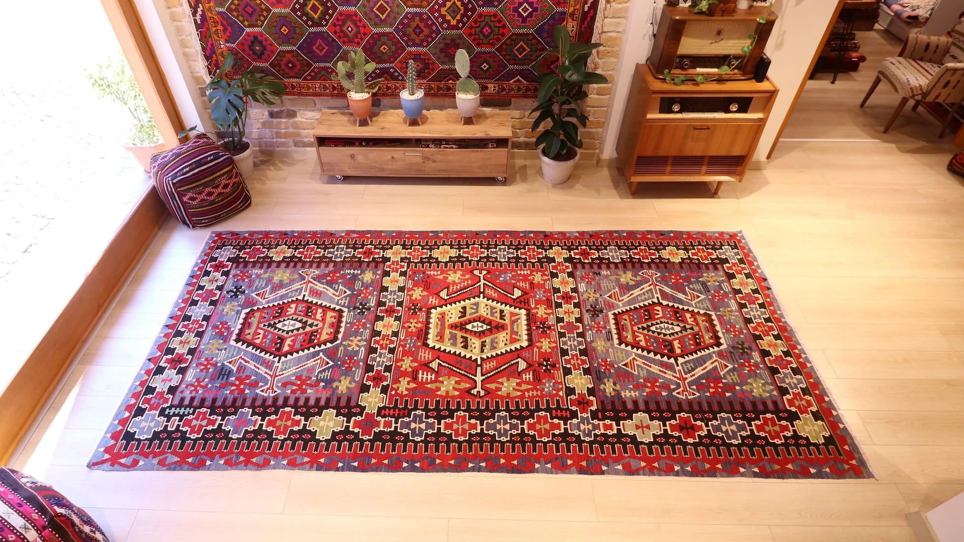 a rustic nomadic Turkish Esme Oushak Rug in many traditional motifs and earthy tones from the mid-century in a NYC rug gallery