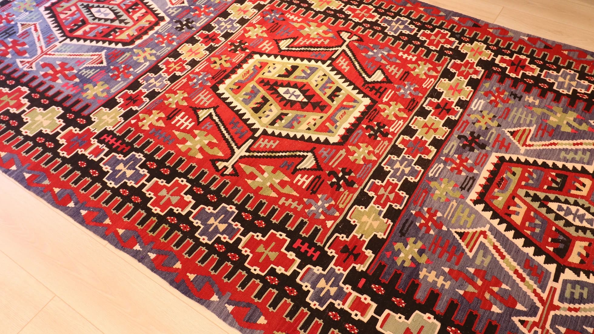 a rustic nomadic Turkish Esme Oushak Rug in many traditional motifs and earthy tones from the mid-century in a NYC rug gallery