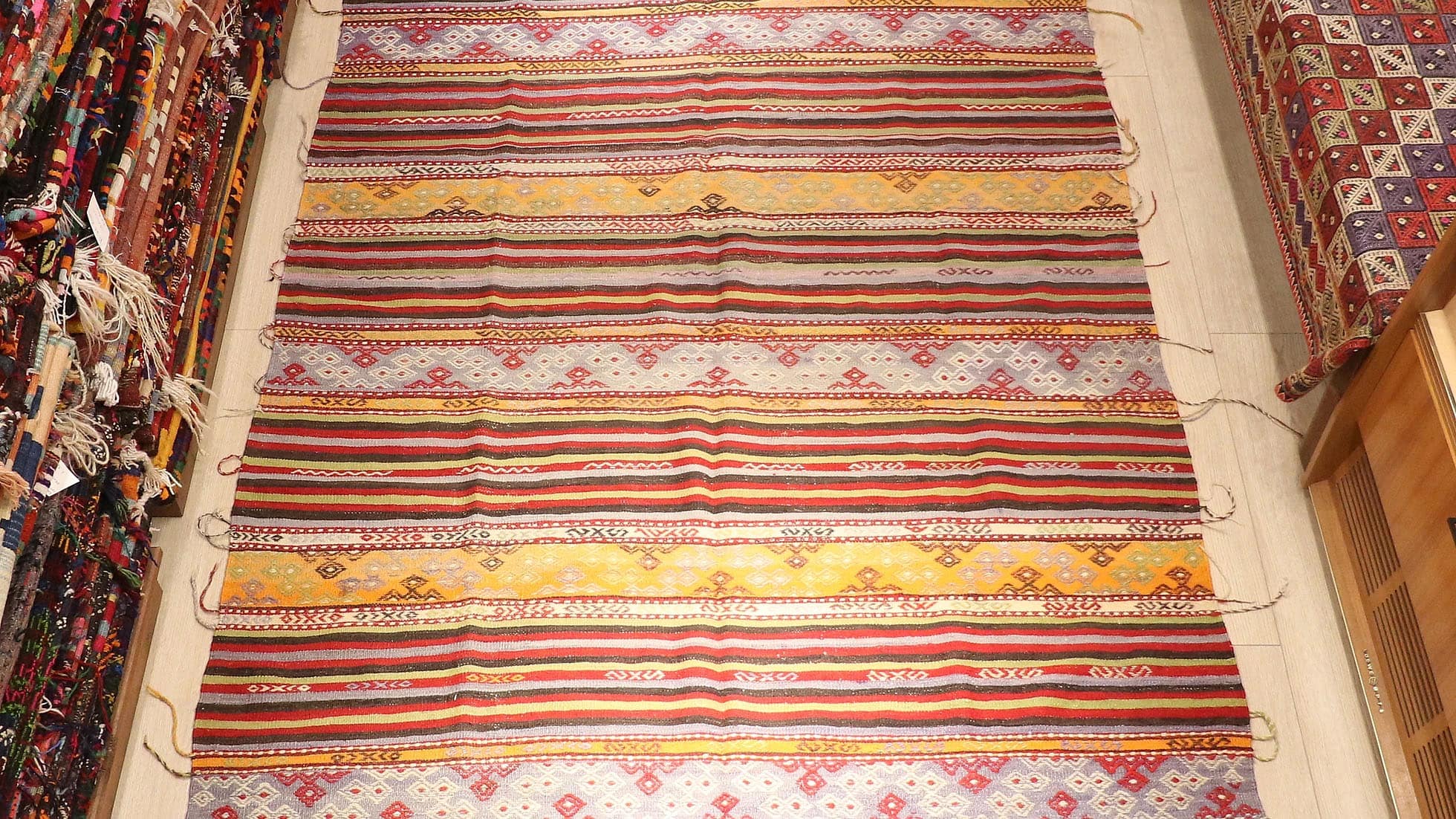 a true authentic and rare mid-century Turkish neutral kilim rug with long tassels in faded and muted pastel hues by Kilim Couture New York rug gallery