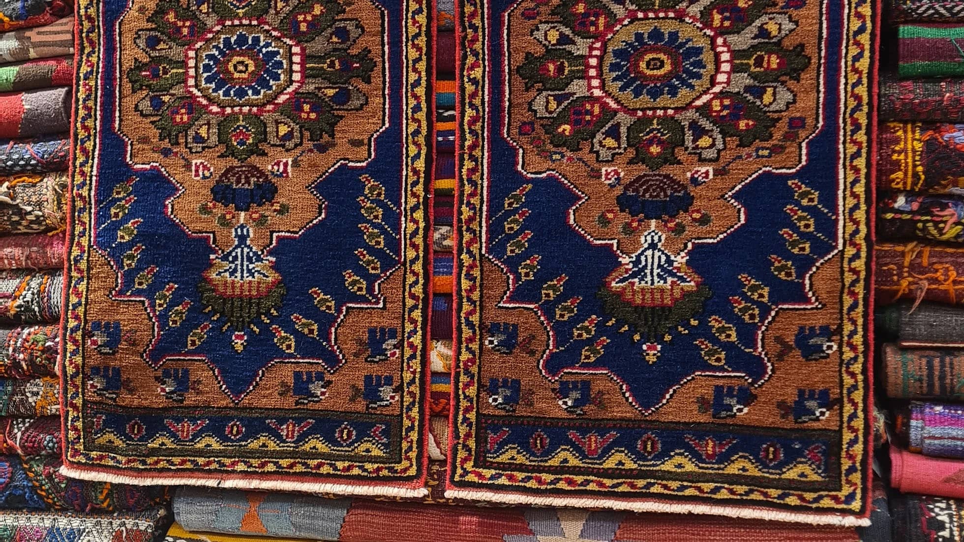 Rare two-piece Mid-Century Konya Oriental rug set, handwoven in Konya, Turkey. Small area rugs with geometric medallion designs in rust, navy blue, mustard, and charcoal, ideal for entryways, hallways, and luxury interiors.