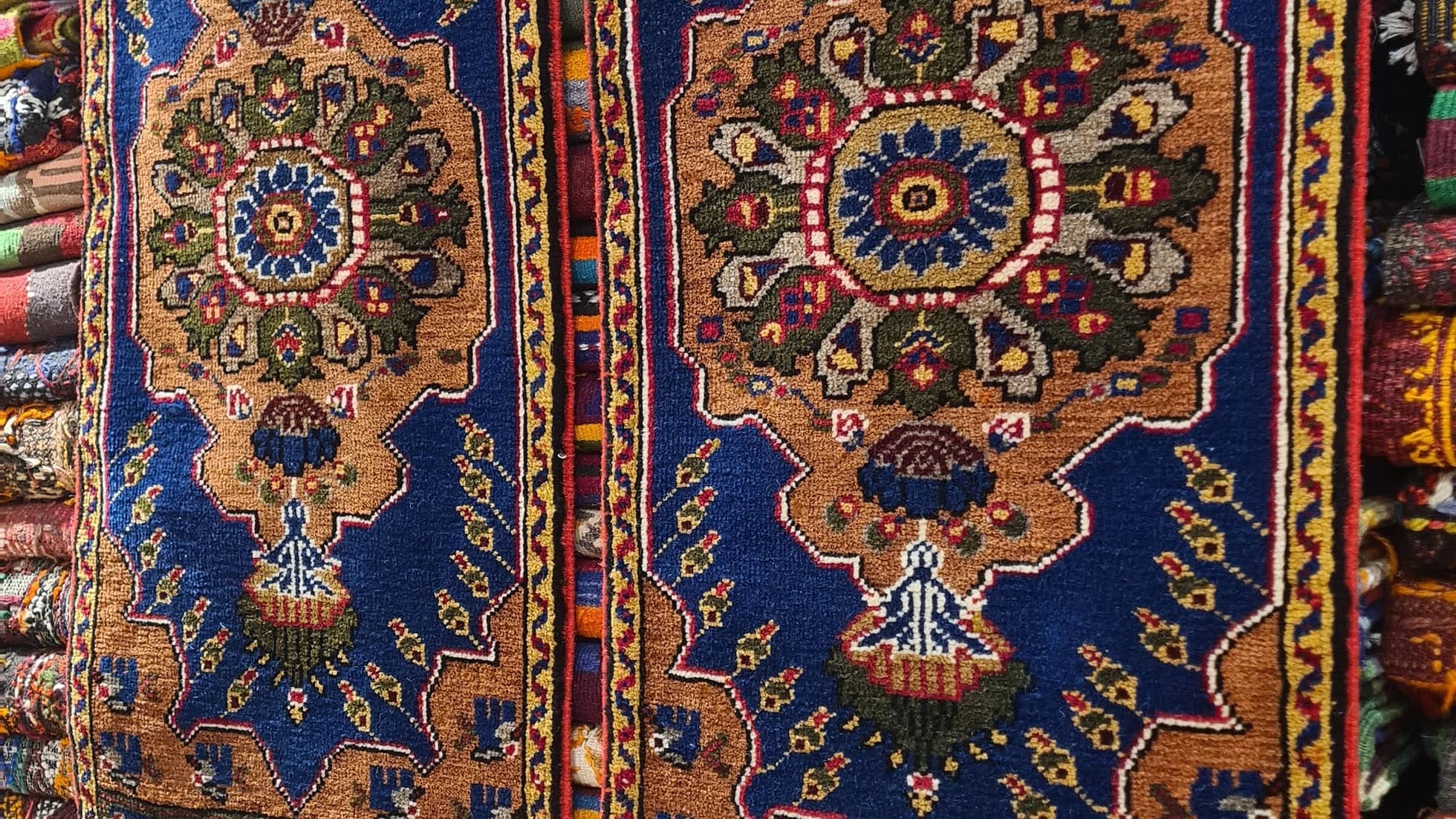 Exclusive two-piece Mid-Century Konya Oriental rug set from Kilim Couture New York, handwoven in Konya, Turkey. These compact small area rugs, ideal as doormats, feature rust, navy, mustard, and charcoal tones with geometric medallion designs, perfect for stylish entryways.