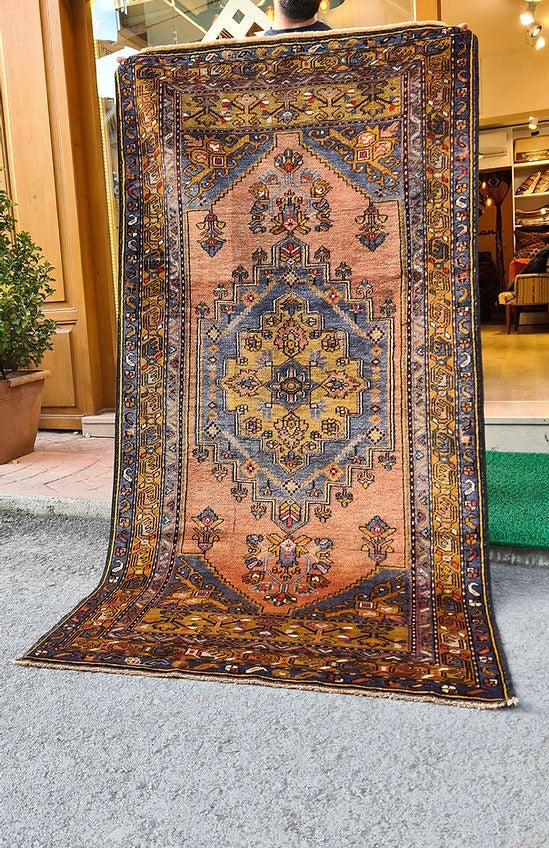Mid-century Yahyali rug from Kayseri, Turkey, 3x7 ft, handwoven with 100% wool. Features a soft dusty peach background with a central floral medallion in powder blue and gold, surrounded by delicate floating motifs and a triple floral border. Crafted using natural dyes from madder root and walnut shells, showcasing traditional Turkish artistry and durable craftsmanship.