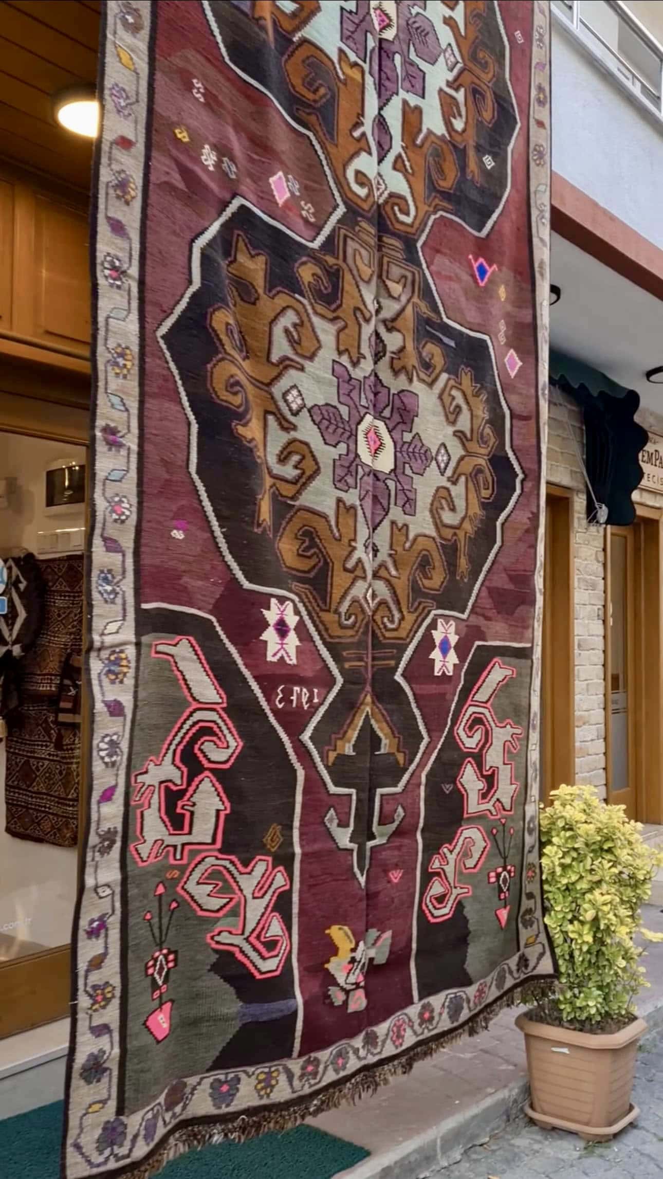 vintage handwoven runner rug with date signature and medallions in floral border