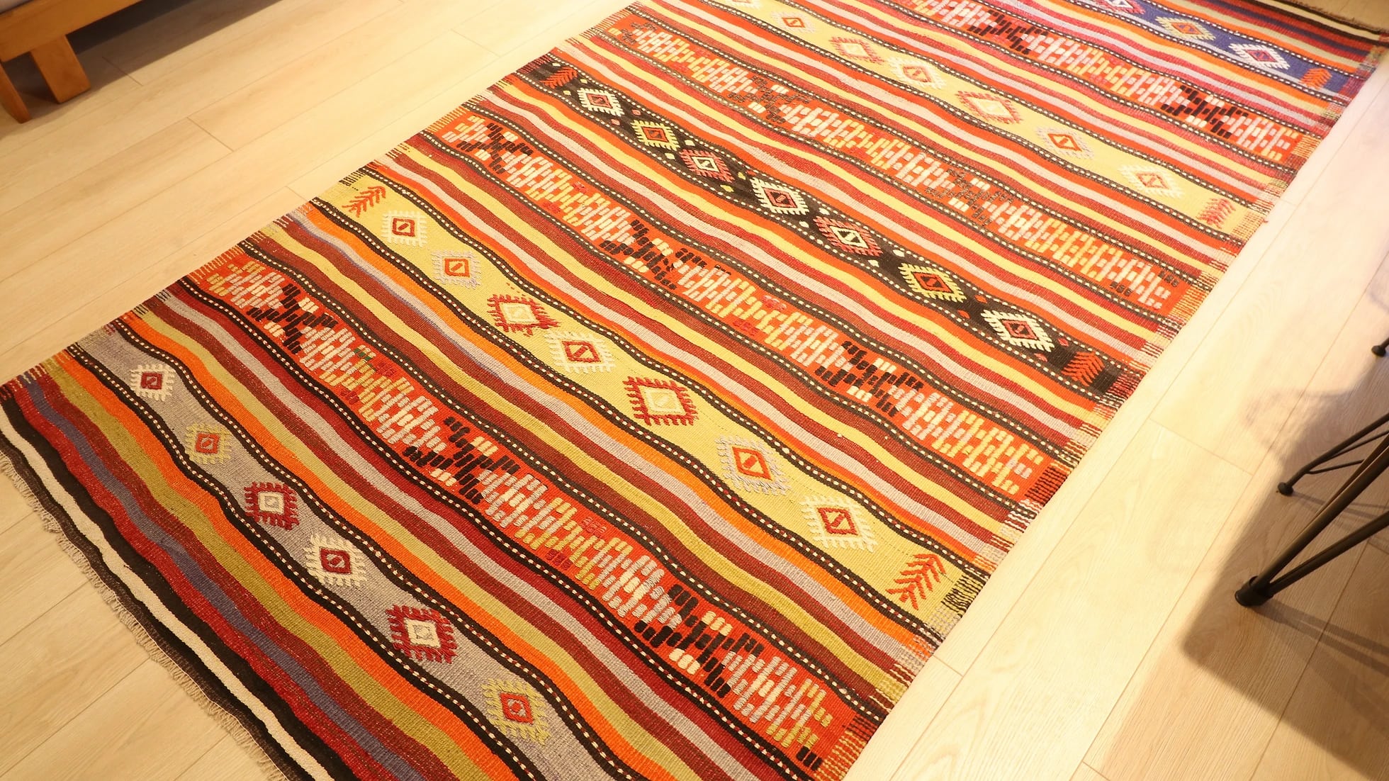 an old vintage handwoven Turkish runner rug in natural rustic hues and traditional stripe patterns