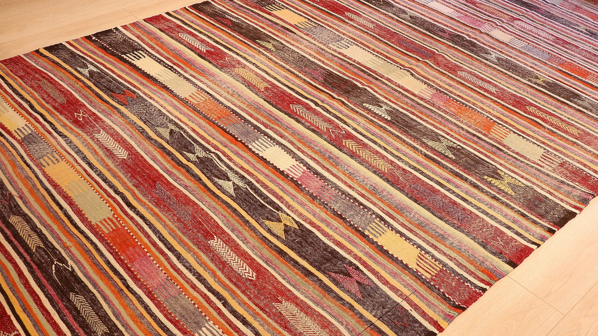 an expansive traditional kilim runner rug in pastel and rustic earth tones with geometric stripe motifs