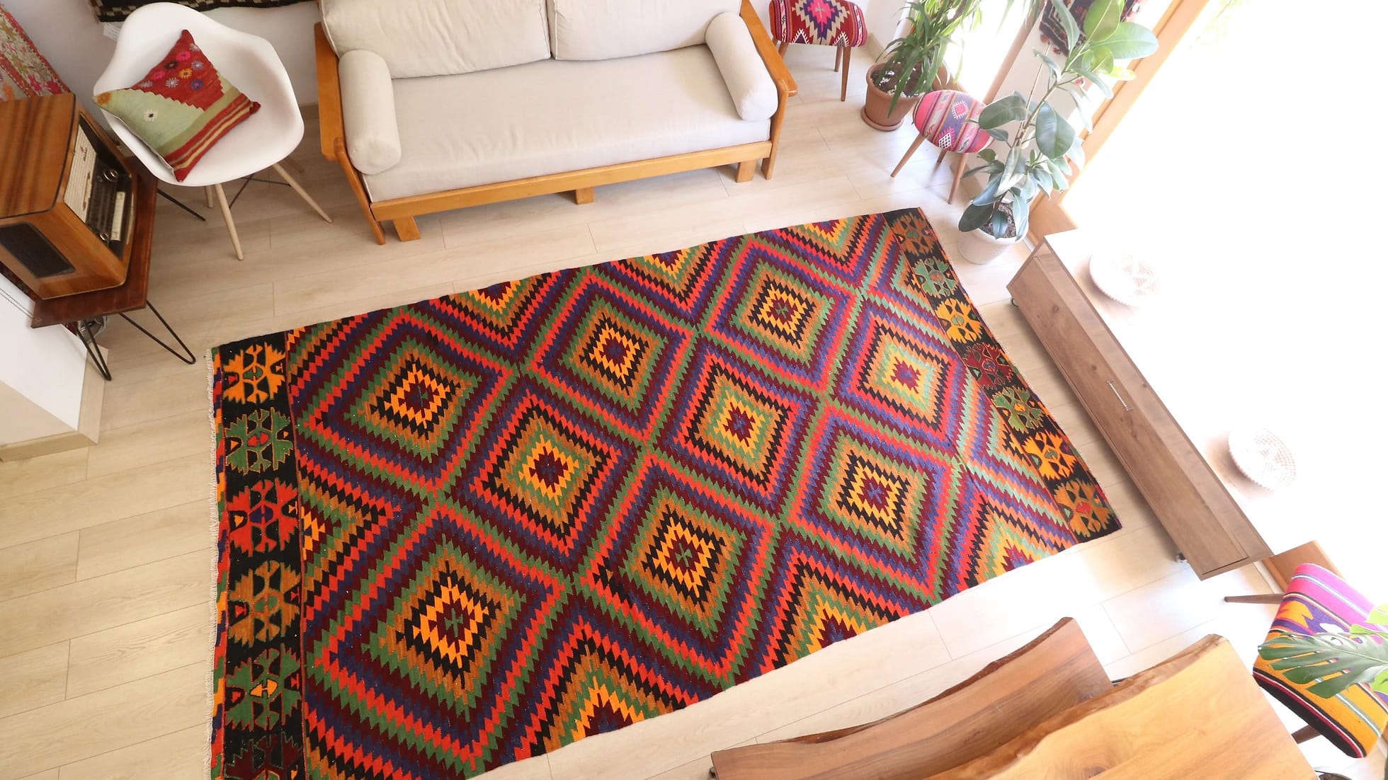 a precious large woolen tribal rug from Turkey featuring rustic and earthy colors and traditional motifs from mid-century