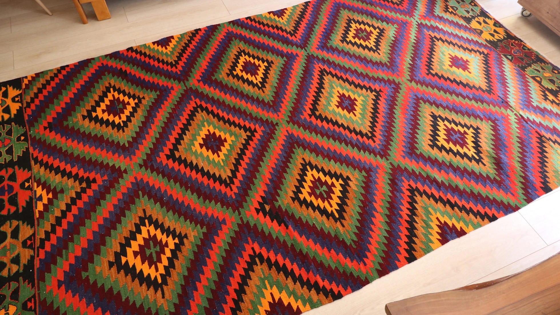 a precious large woolen tribal rug from Turkey featuring rustic and earthy colors and traditional motifs from mid-century