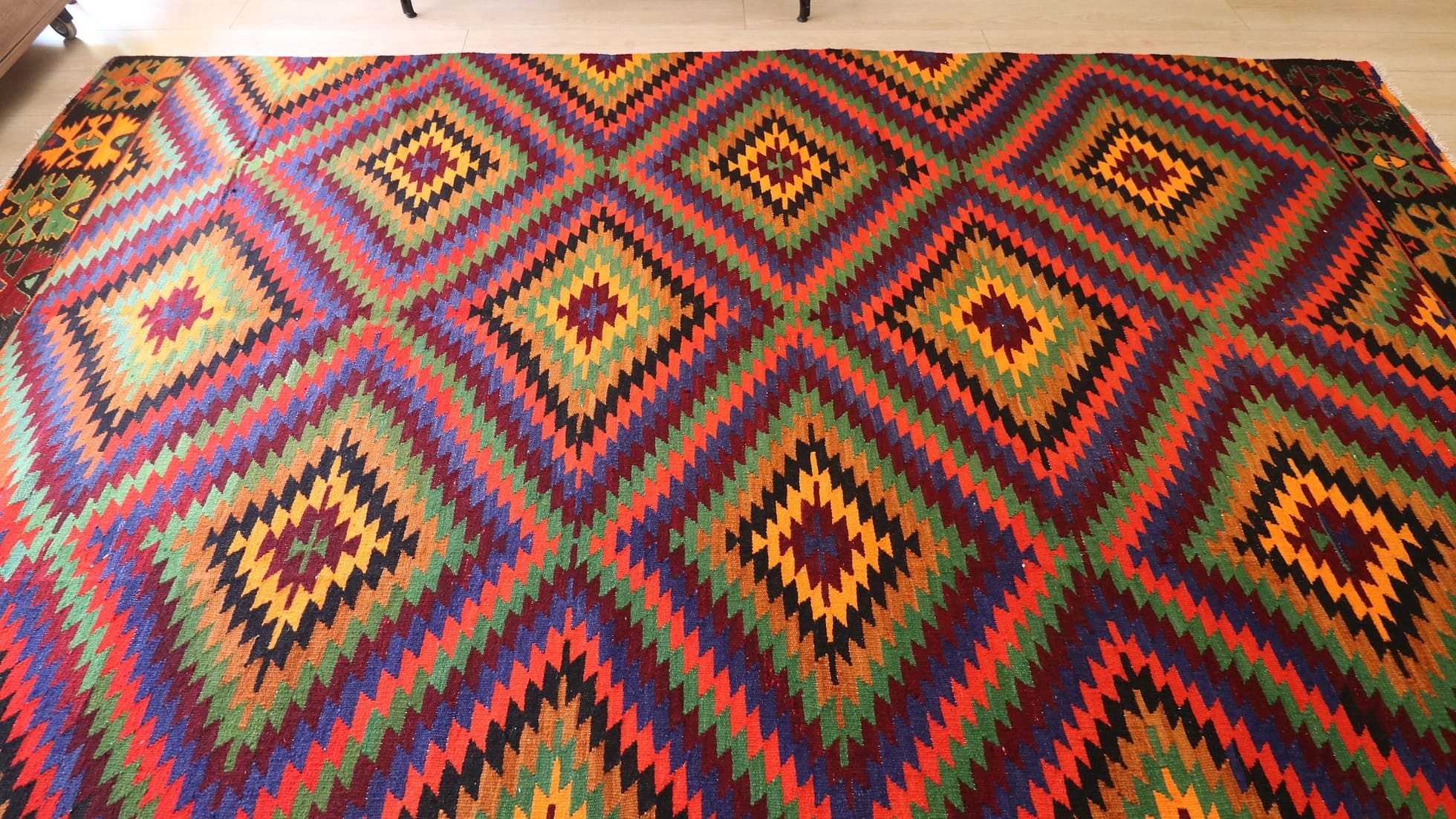 a precious large woolen tribal rug from Turkey featuring rustic and earthy colors and traditional motifs from mid-century