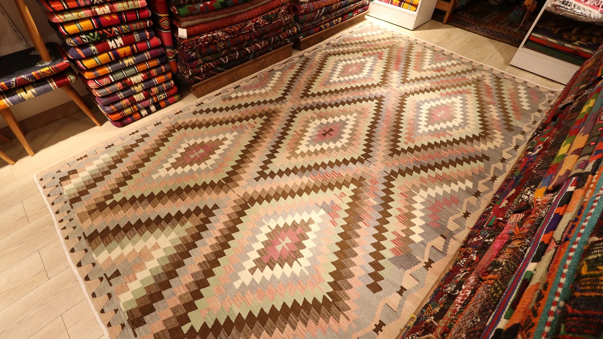 a rare large area rug from western Anatolia in pastel and neutral muted tones and diamond/lozenge patterns in our New York rug store