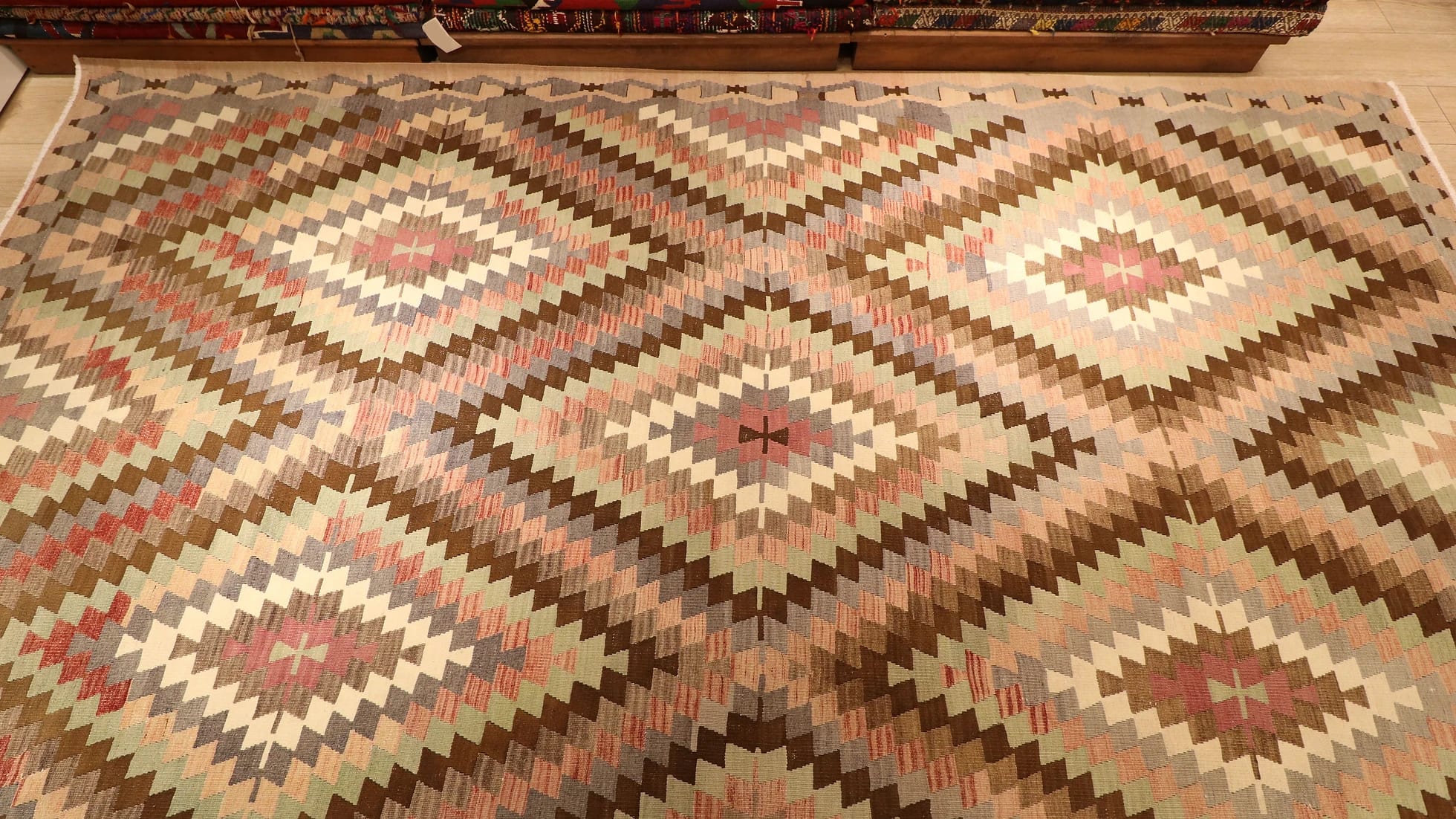 a rare large area rug from western Anatolia in pastel and neutral muted tones and diamond/lozenge patterns in our New York rug store