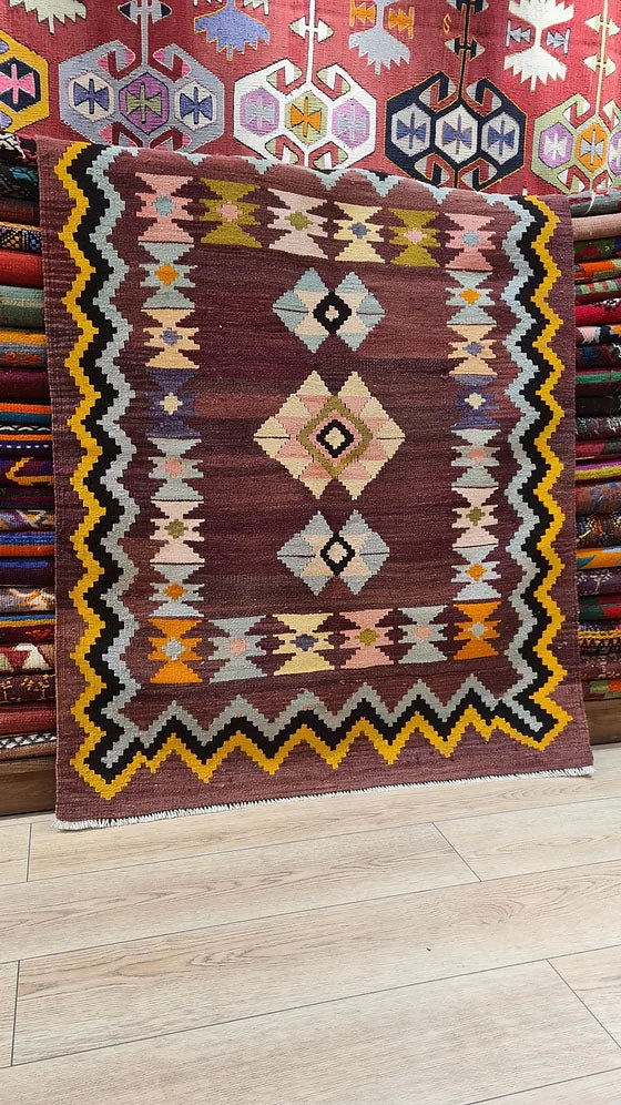 Vintage Handwoven Milas Kilim Rug, 4x5 ft, featuring a mocha mousse background with muted tones of rosewater pink, lavender mist, and tangerine peel. Adorned with intricate 'hair band' and 'running water' motifs, this artisan-crafted piece blends heritage and sophistication.