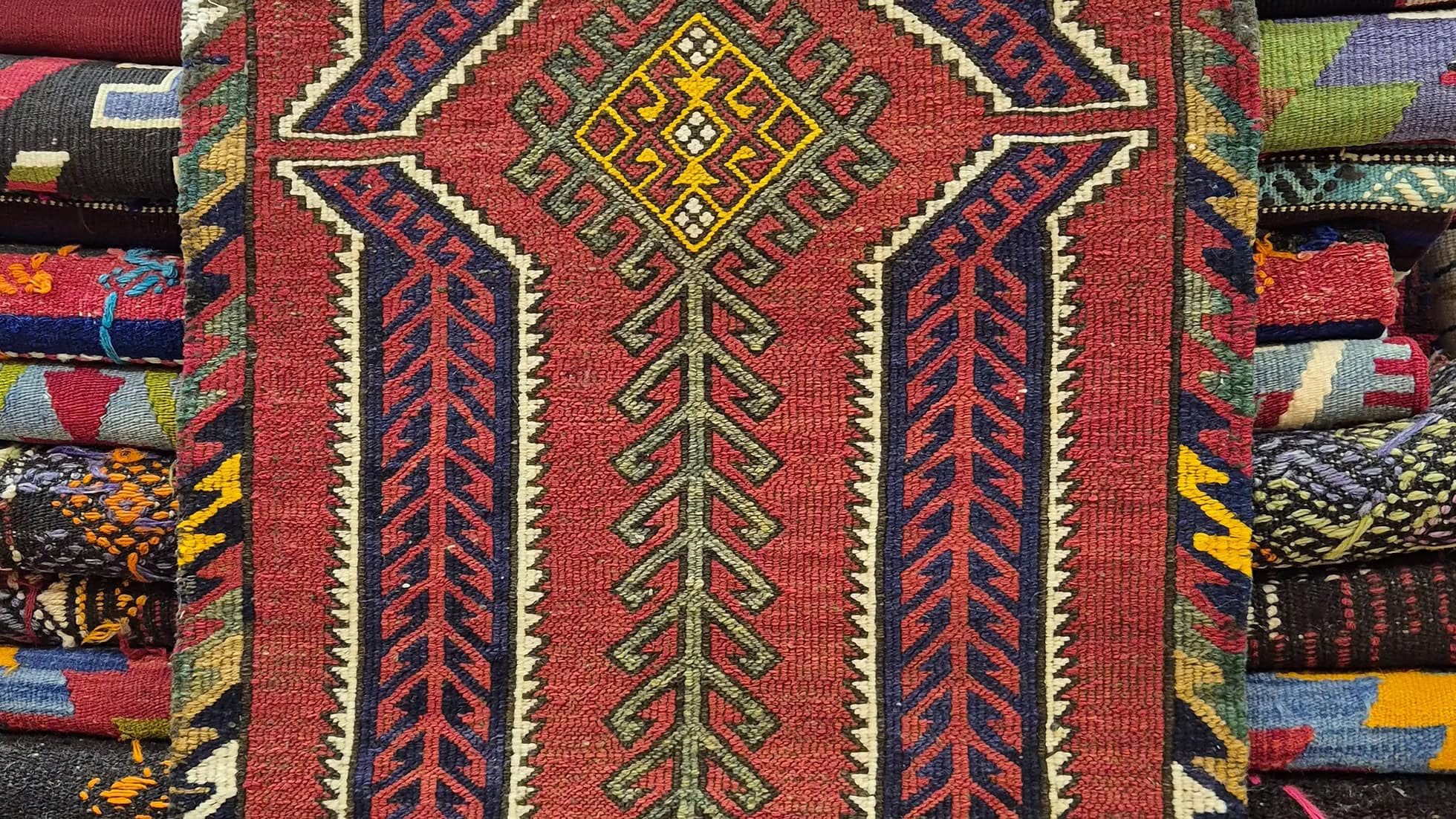 Close-up of a patterned cecim sumak rug with vibrant colors and intricate designs.