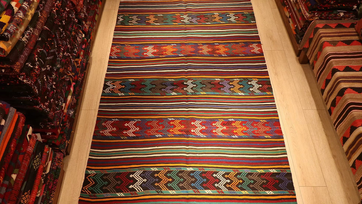 Antique Turkish kilim rug with intricate cicim stitching, showcasing vibrant coral, aqua, indigo, and burnt sienna hues, handcrafted by Aegean Yoruk artisans.