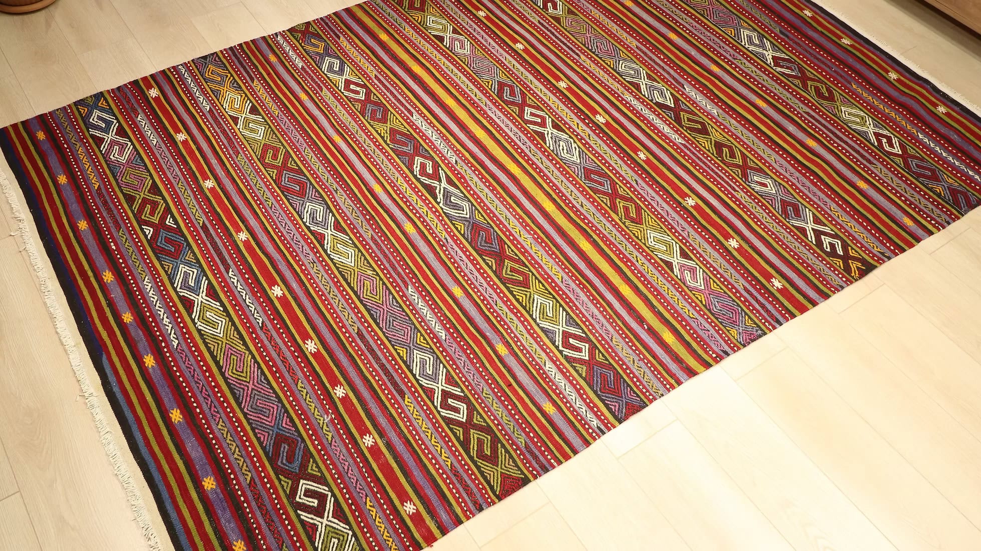 Detailed photo of vintage Balikesir kilim highlighting the quality wool weave and vibrant color palette of cherry red, saffron gold, and pistachio green, ideal for adding cultural heritage and warmth to any space.