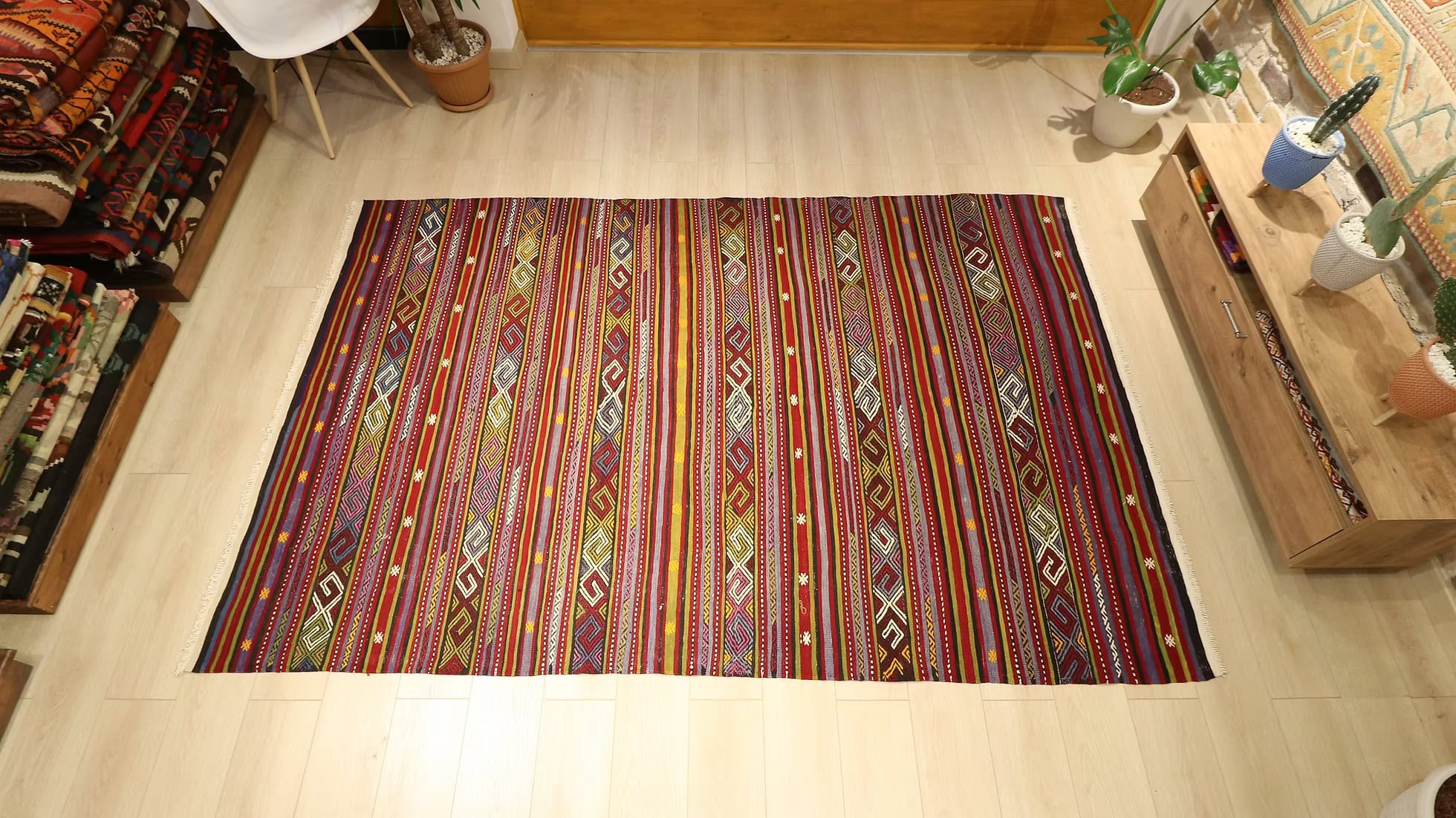 Full shot of a vintage flat-woven large area rug from Kilim Couture, featuring intricate stripes and a harmonious blend of vibrant and earthy tones, perfect for an elegant home decor.