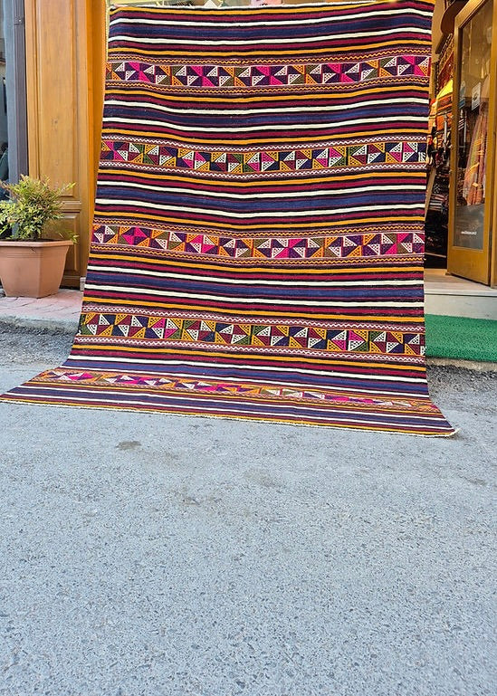 Vintage colorful striped 6x9 area rug, a classic example of Turkish textile artistry.
