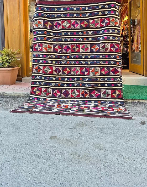 Jewel-toned 5x8 kilim rug in maroon, magenta, and ivory for cottage and farmhouse interiors.