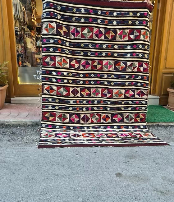 Vintage Turkish pink kilim rug, 5x8 ft, ideal for rustic, cottage, or farmhouse interiors.
