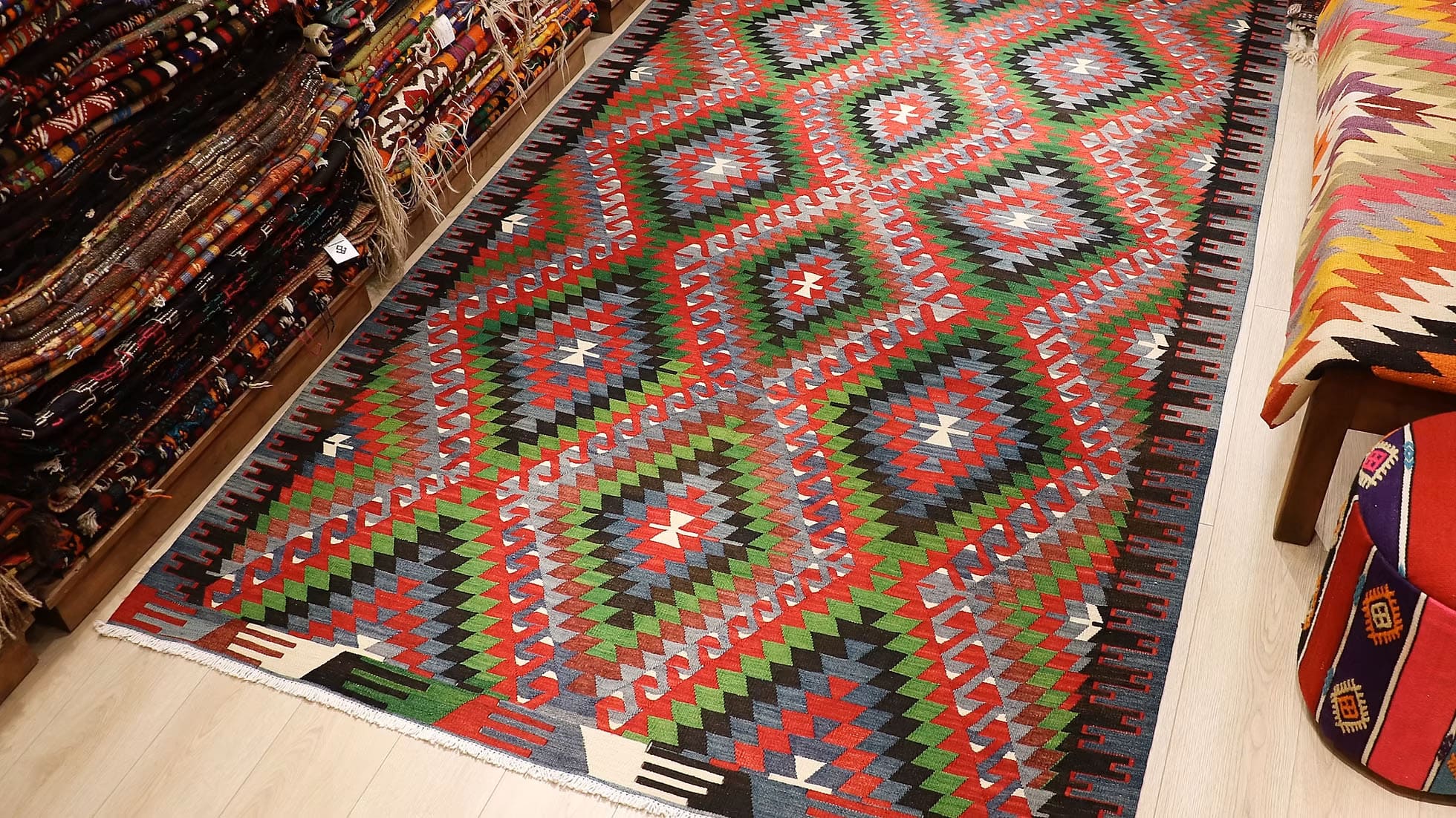 Vintage Turkish Denizli Kilim. This rare 1950s handwoven kilim from Denizli, Turkey, features a striking royal crimson backdrop with intricate 'comb' border motifs in onyx truffle and smoky gray. Measuring 6x10, its bold lozenge pattern embodies the rich craftsmanship of Anatolian weaving. A timeless fusion of history and elegance, this versatile heirloom rug adds warmth and sophistication to any space.