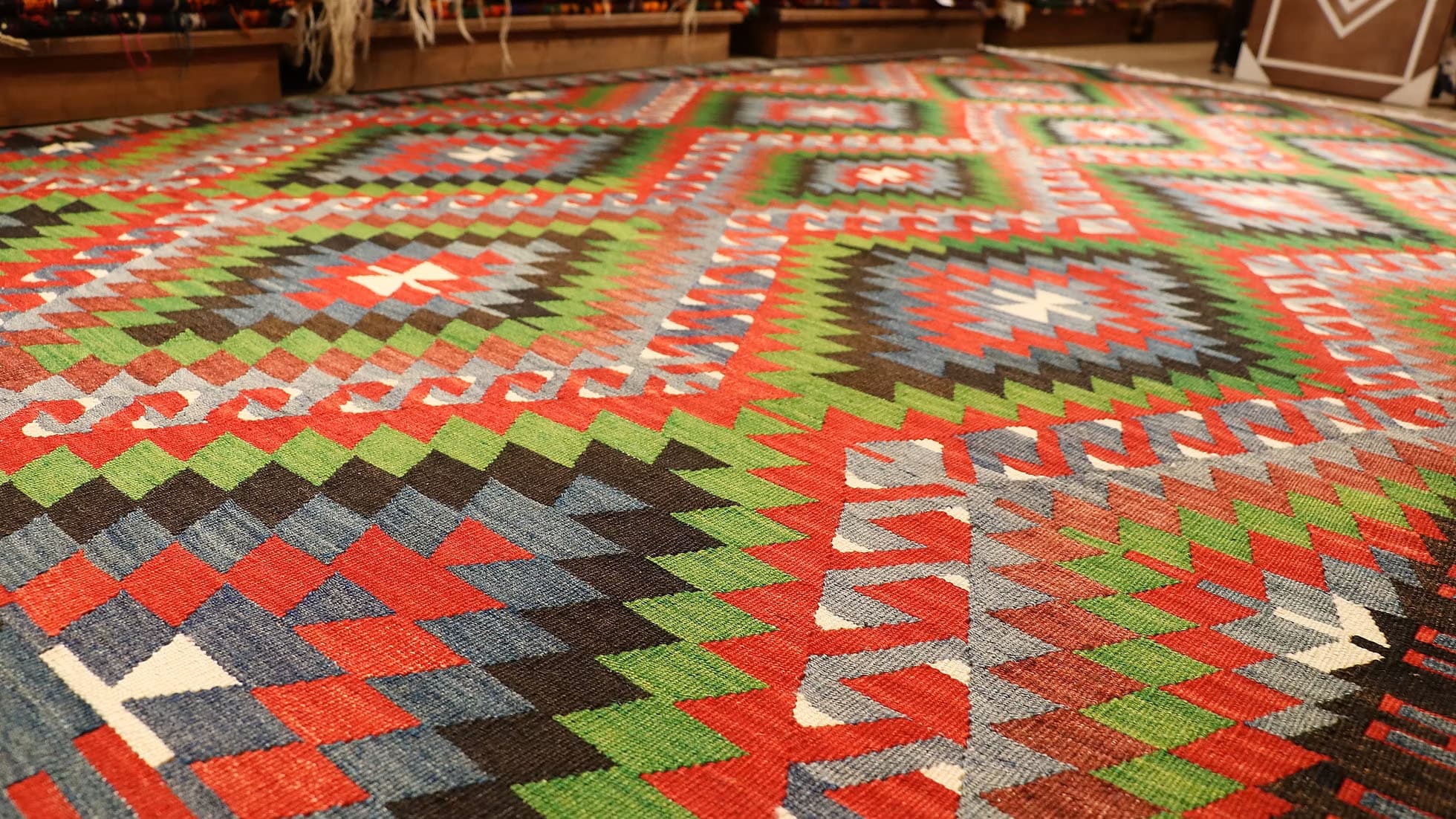 Vintage Turkish Denizli Kilim. This rare 1950s handwoven kilim from Denizli, Turkey, features a striking royal crimson backdrop with intricate 'comb' border motifs in onyx truffle and smoky gray. Measuring 6x10, its bold lozenge pattern embodies the rich craftsmanship of Anatolian weaving. A timeless fusion of history and elegance, this versatile heirloom rug adds warmth and sophistication to any space.