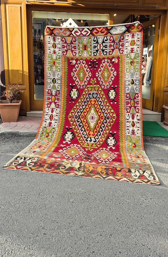 Vintage mid-century Turkish geometric kilim rug, 6x10 ft, handwoven with a bold tribal diamond medallion and naturally faded colors.