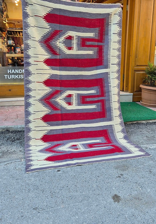Vintage Turkish Usak rug featuring muted almond dust background and intricate comb motifs in stone gray and pomegranate.
