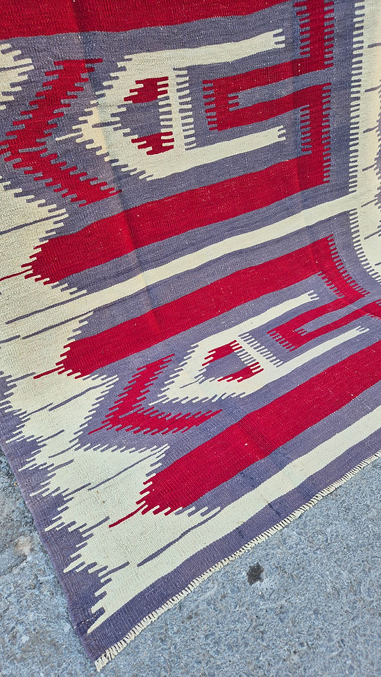 Minimalist Oushak Esme kilim displayed in a contemporary loft entrance with soft gray and warm pomegranate tones.