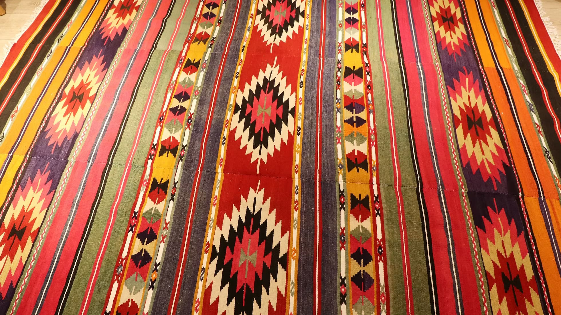 Close-up of Kilim Couture New York's vintage Turkish kilim, highlighting intricate geometric designs in Southwestern hues.