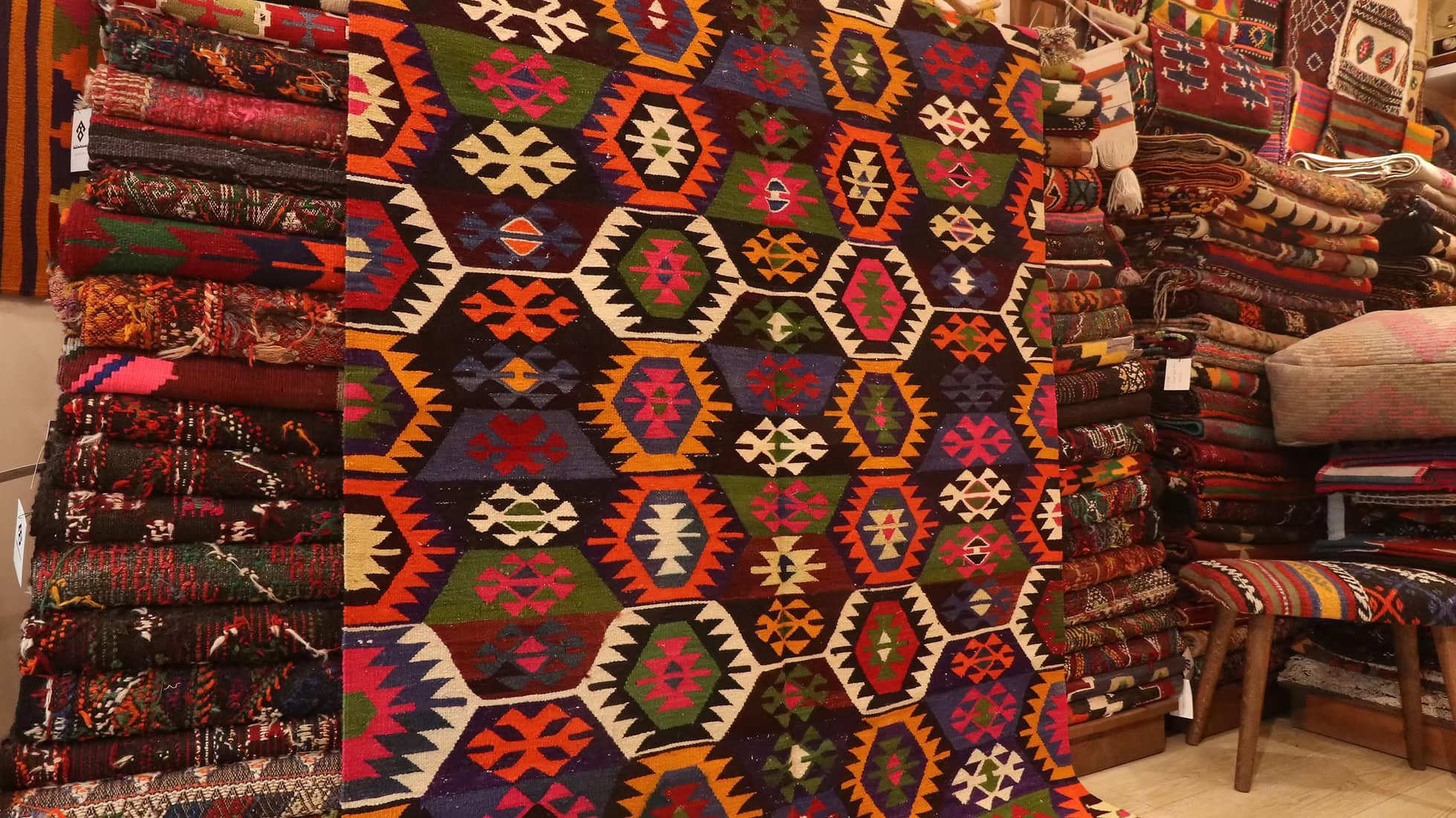 Handwoven vintage kilim from Tavas, Denizli, showcasing vibrant orchid fuchsia, golden marigold, pistachio crème green, and terracotta clay red. With intricate lozenge and 'wolf’s mouth' motifs symbolizing protection and prosperity, this 50-60-year-old rug embodies Anatolian artistry and heritage. A timeless piece with delicate hand-knotted tassels, perfect for adding rustic elegance and history to any space.