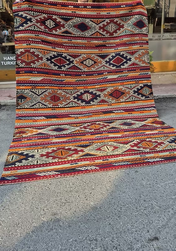 Sustainable tribal kilim rug in muted sun-baked orange, pomegranate blush, and marine blue tones by Kilim Couture Rug Store in NYC.