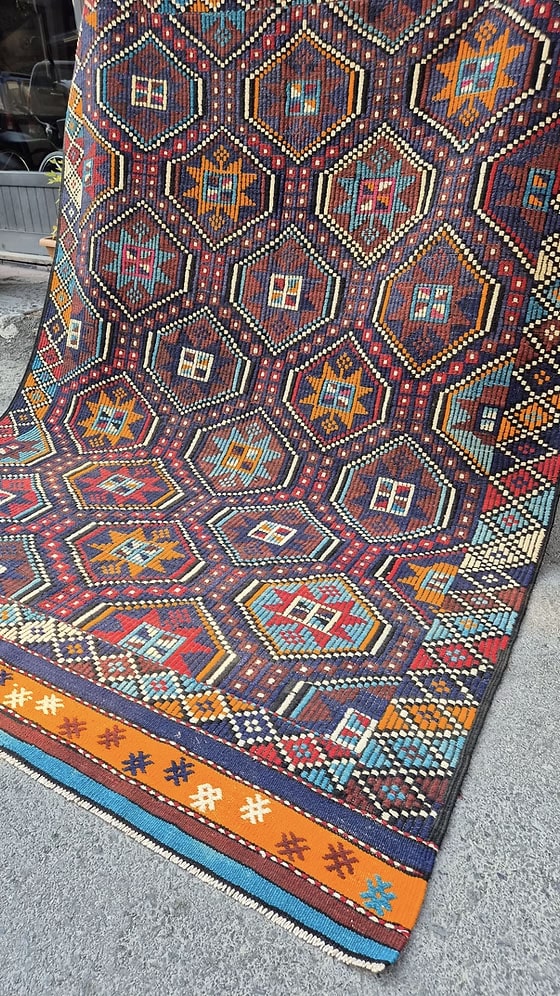 Mid-century modern vintage kilim rug with geometric star patterns and rich texture, ideal for curated layered interiors and maximalist living rooms