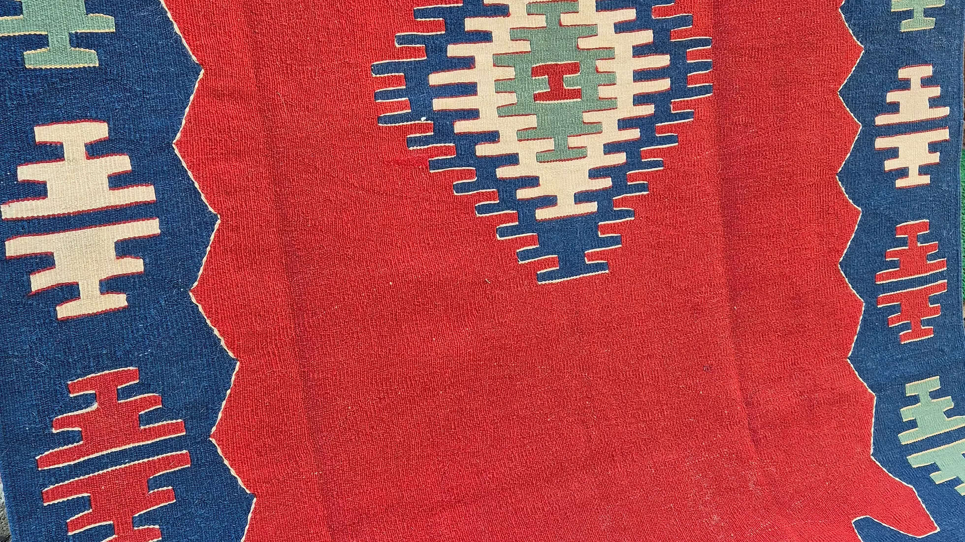 Close-up of a handwoven Turkish kilim rug by Kilim Couture New York showcasing burnished brick and inkstone blue patterns