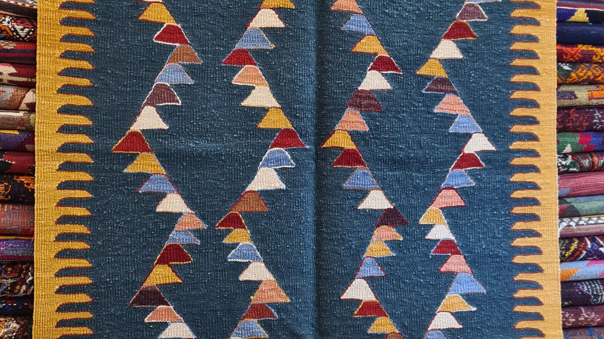 Turkish oushak flat-weave with geometric pattern featuring triangles on a blue background