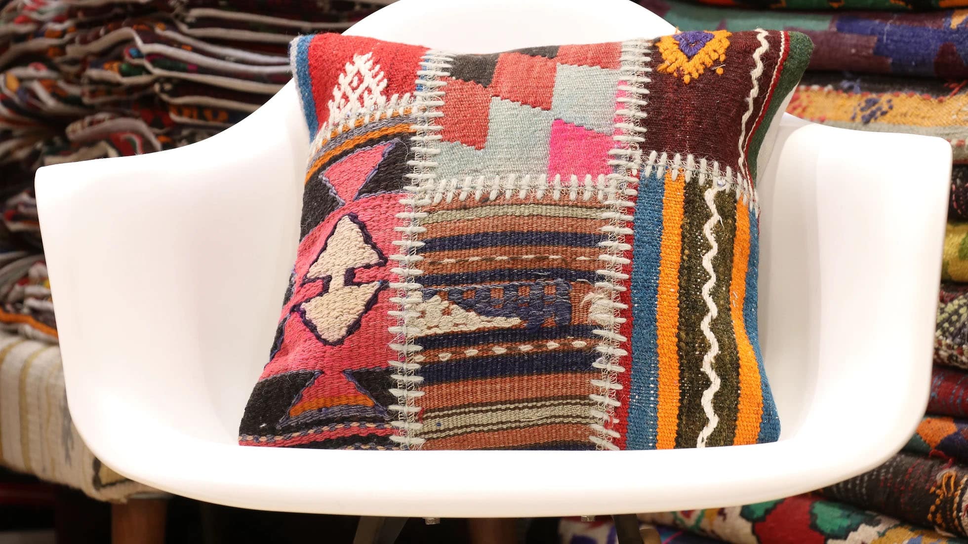 Vintage handwoven patchwork kilim pillow with geometric tribal motifs, crafted from repurposed mid-century kilim fragments in warm earth tones. Ethically made and supports women artisans.