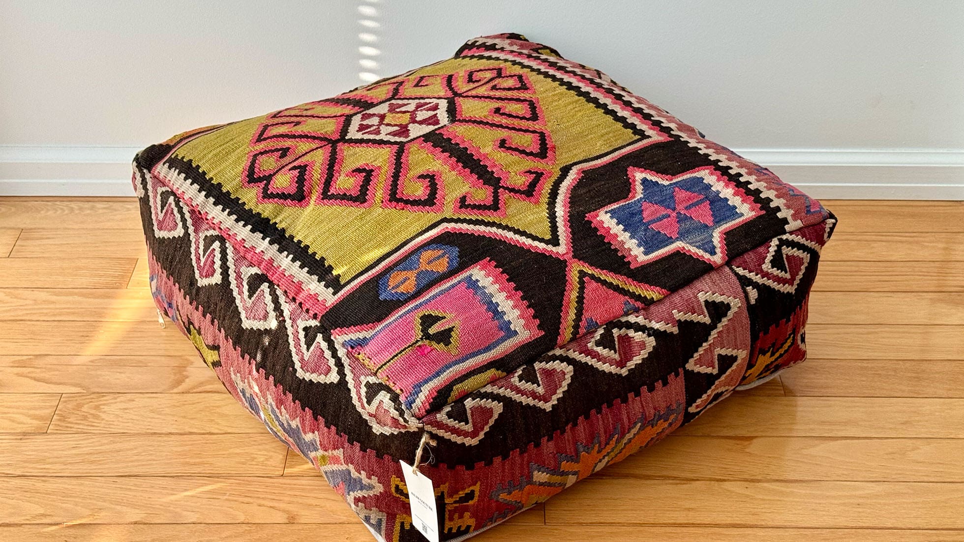 Vintage Kilim Ottoman Pouf by Kilim Couture New York in mustard yellow, salmon, and denim blue with traditional geometric patterns, handwoven from a Turkish rug, ideal for boho, eclectic, and modern farmhouse home decor