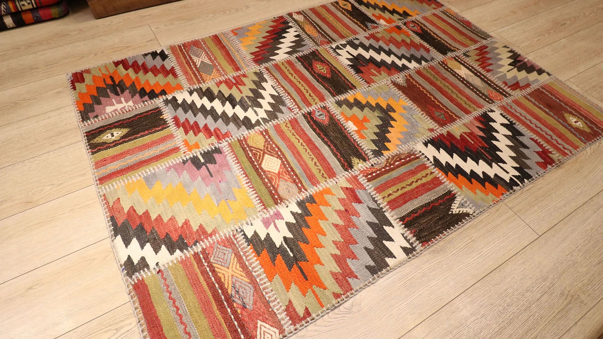 a beautiful and precious semi-antique tribal patchwork flat-weave rug in muted and faded hues in geometric stripes