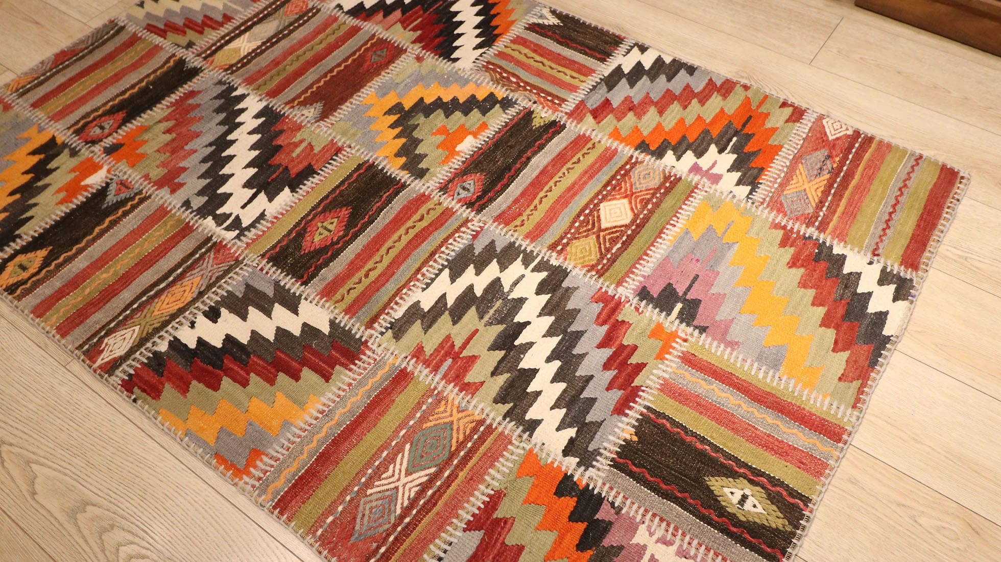 a beautiful and precious semi-antique tribal patchwork flat-weave rug in muted and faded hues in geometric stripes