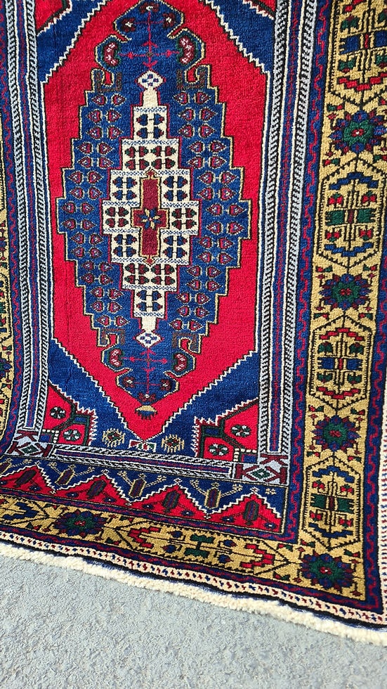 Hand-knotted in Taspinar, Turkey, this semi-antique 4x6 ft. rug features a striking medallion with intricate floral patterns in crimson, gold, and azure. Made from pure wool and dyed with natural pigments, it offers unmatched durability and elegance. Perfect for hallways, entryways, or kitchens, this rug blends Anatolian heritage with timeless design.