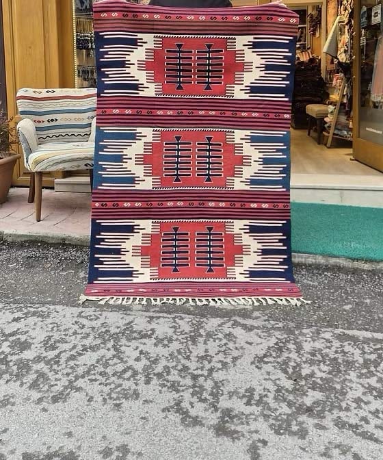 Navajo-style Southwestern flat-weave rug in madder red, indigo navy, and soft oat tones