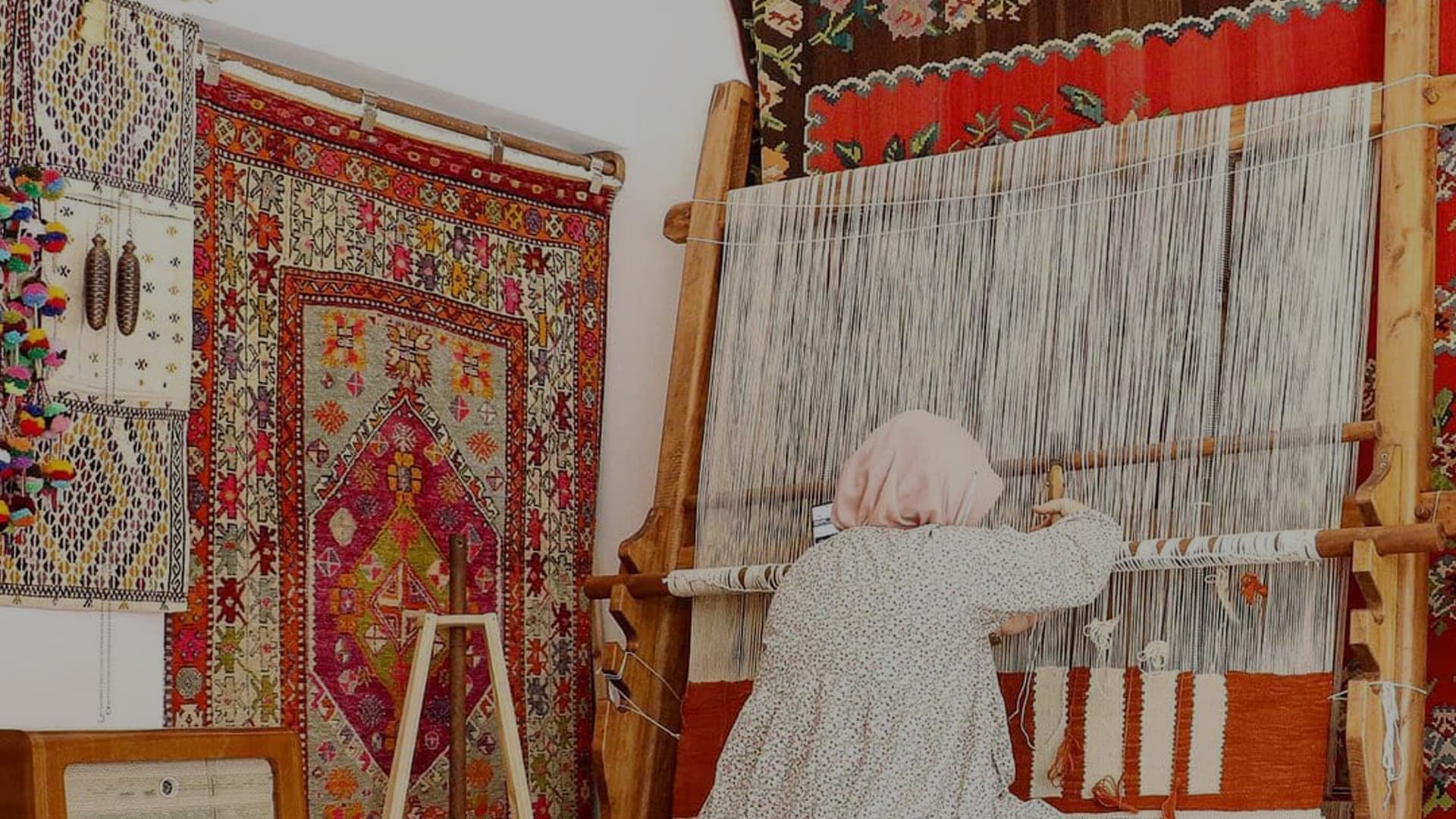 a traditional Turkish woman weaving a red oriental rug meticulously and sustainably