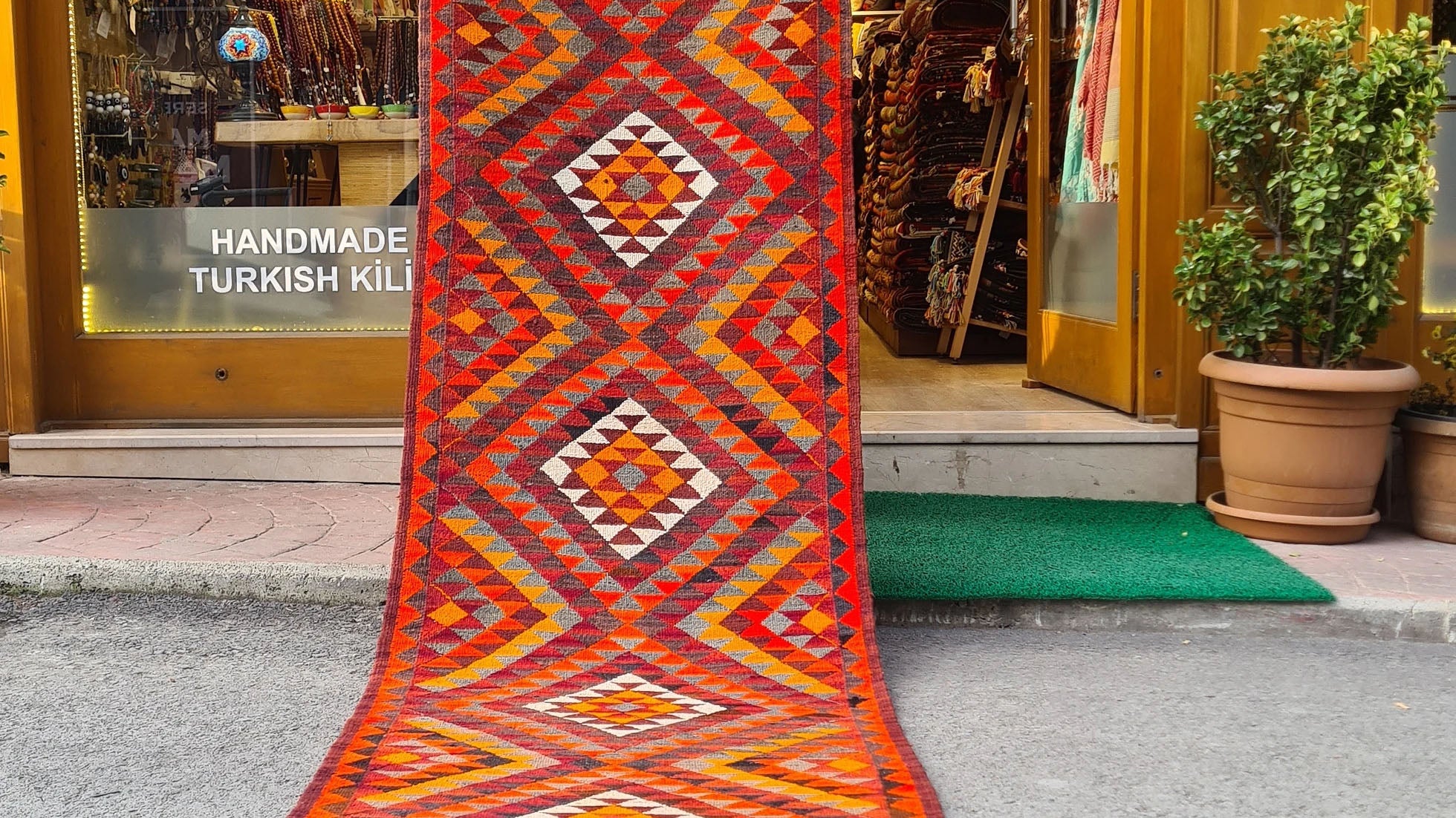 Artisan-made Afghan runner, 3x12 ft, featuring a bold diamond flat-weave design in vermilion red, persimmon orange, and ochre yellow. Durable and versatile, ideal for hallways, kitchens, or entryways, blending tradition with modern style.