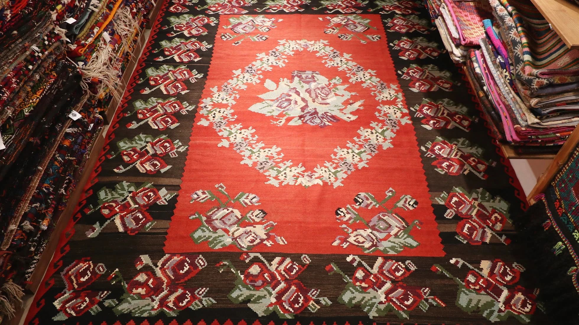 Vintage Moldavian Bessarabian Rug, 8x10 ft. This handwoven treasure showcases a deep crimson backdrop adorned with intricate floral bouquets in lavender, cream, sage, and aqua. Perfect for eclectic or bohemian interiors, its timeless European design adds character and warmth to any space.