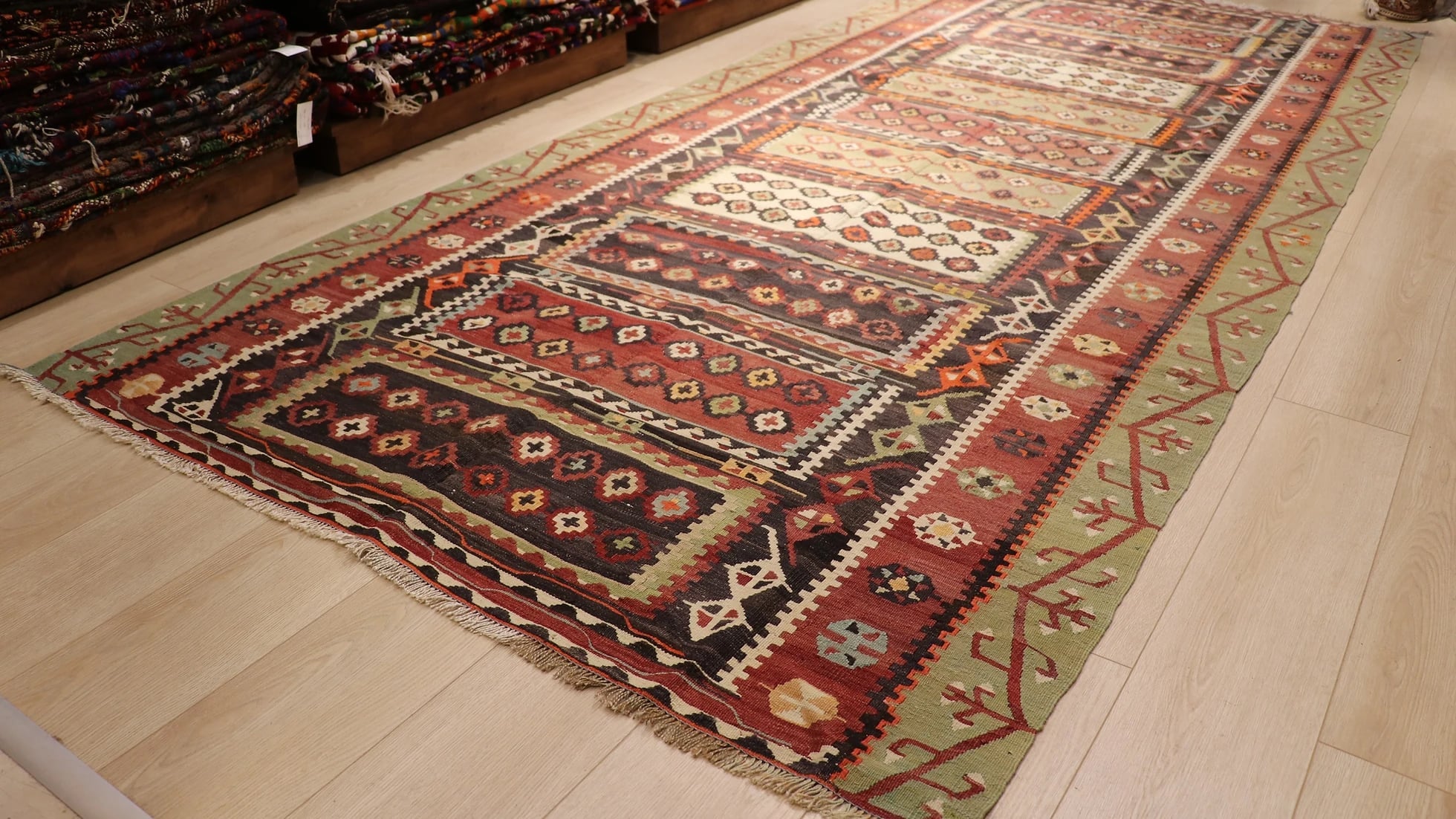 hand-knotted Turkish wool mid-century kilim rug in earthy red, green, brown tones with distinctive traditional motifs