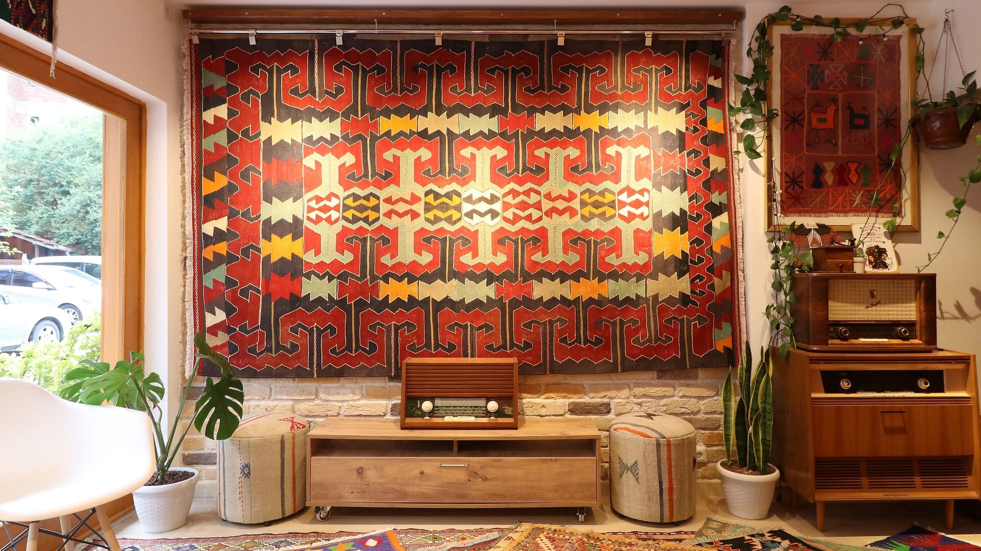 eclectic Anatolian rug showcasing gorgeous traditional motifs in bold terracotta and black colors hung on the wall as a Turkish tapestry rug
