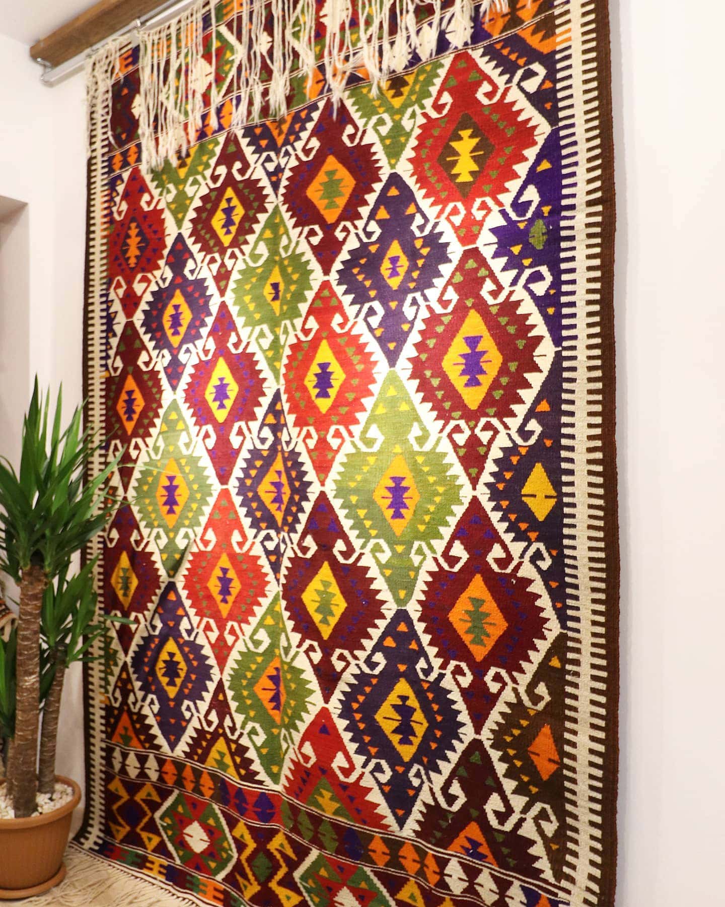 a luxury nomadic handwoven vintage Turkish kilim rug from Antalya in rustic earth tones and tribal motifs