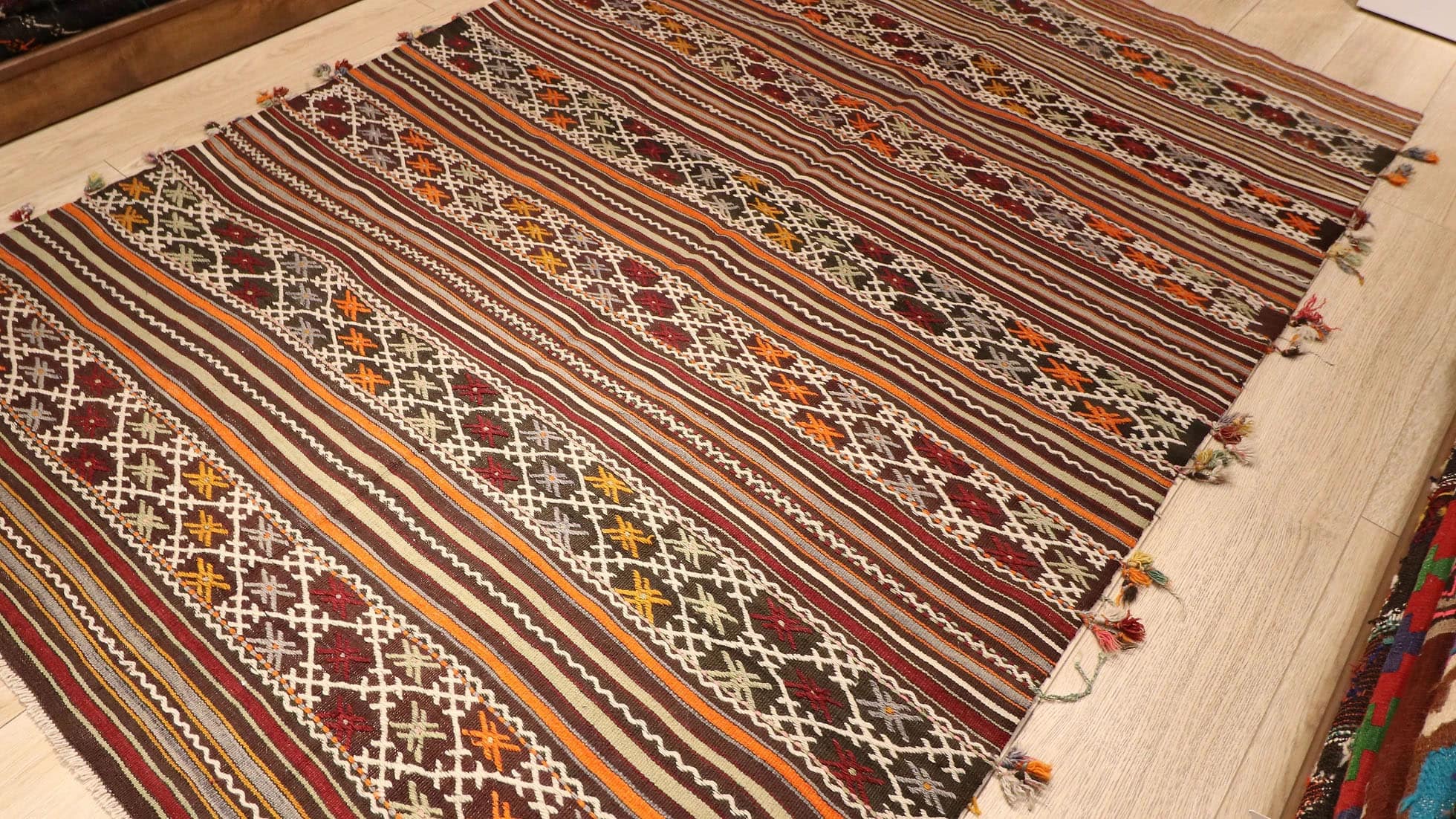 a very rare semi-antique Turkish rug with intricate tassels in rustic, neutral, earthy, and pastel color palette