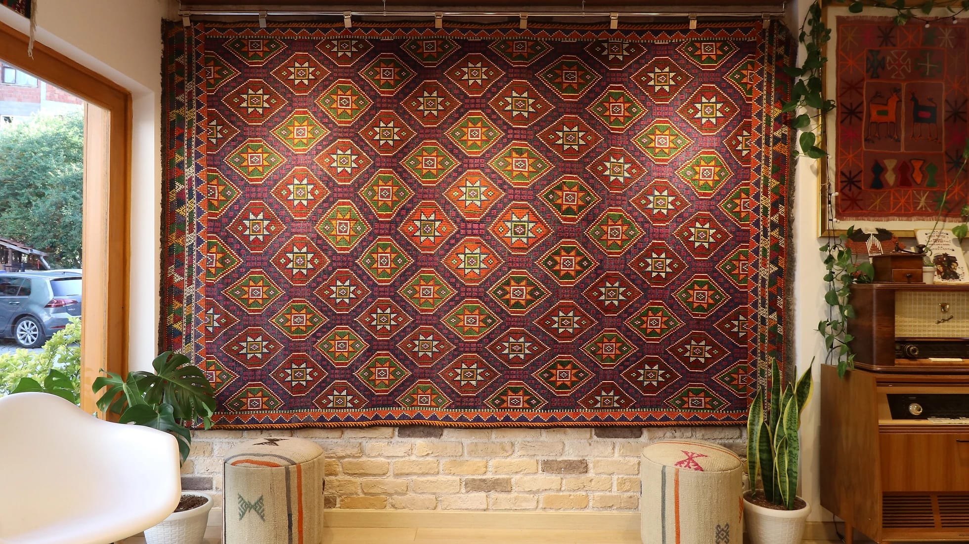 a gorgeous handwoven Turkish flat-woven tribal rug in muted and faded colors hanging on the wall as a Turkish tapestry