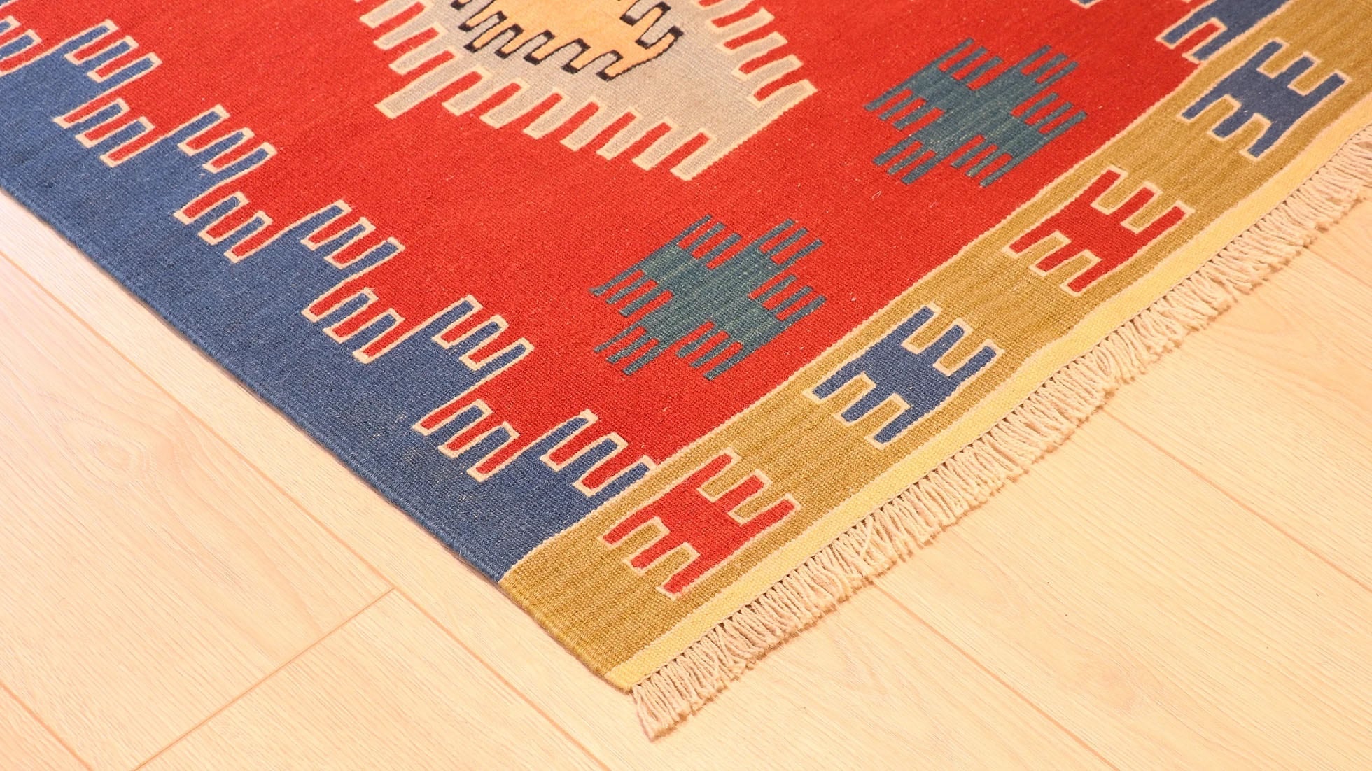 meticulously woven tiny tassels of a small and captivating Ushak kilim rug in red, blue, and gold by Kilim Couture New York