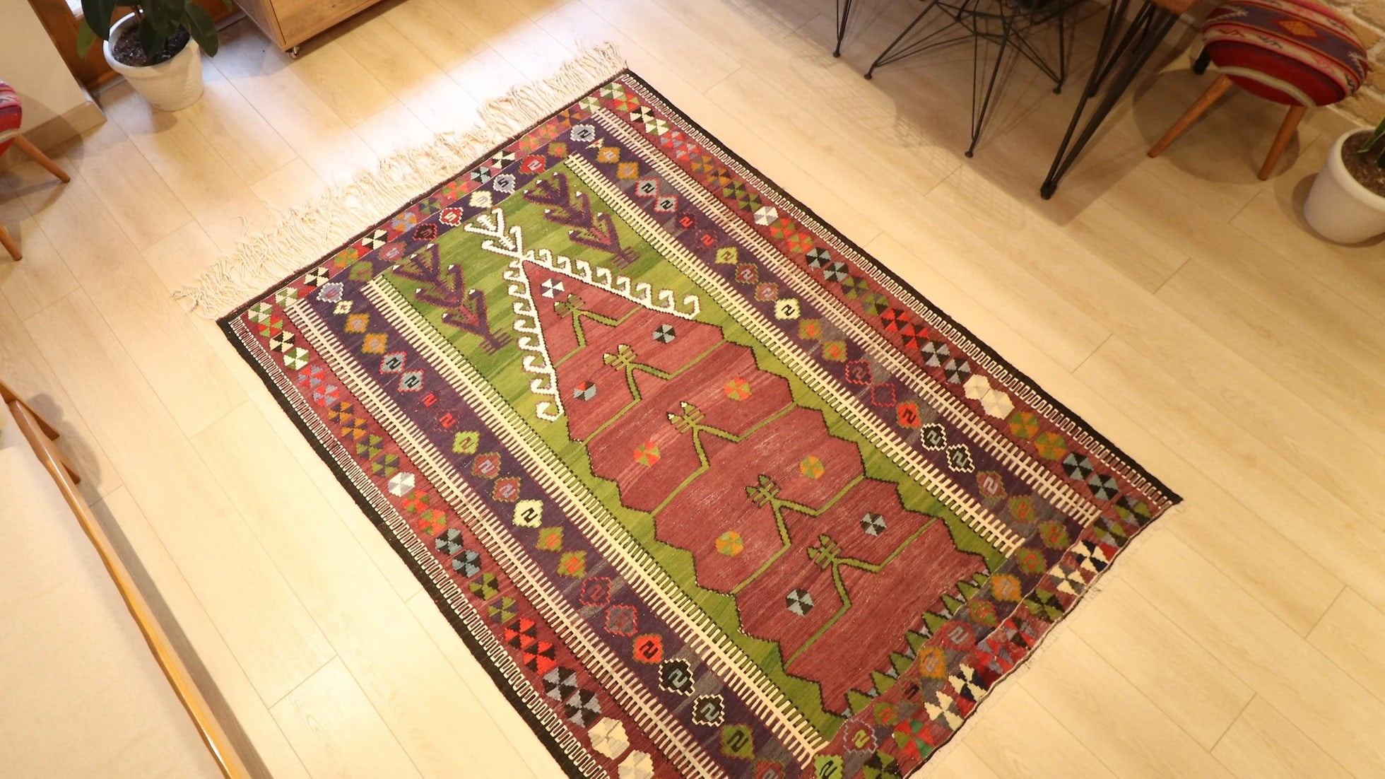 medium-sized handwoven Konya prayer rug with long white fringes featuring many traditional motifs and rustic colors