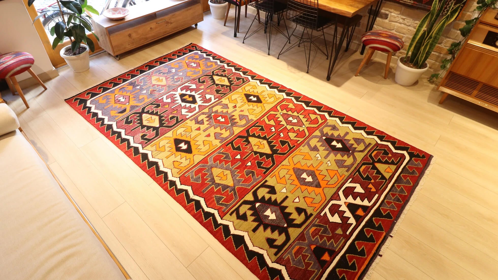 traditional hand-knotted Turkish rug from mid-century in red, black, green, and purple with geometric patterns